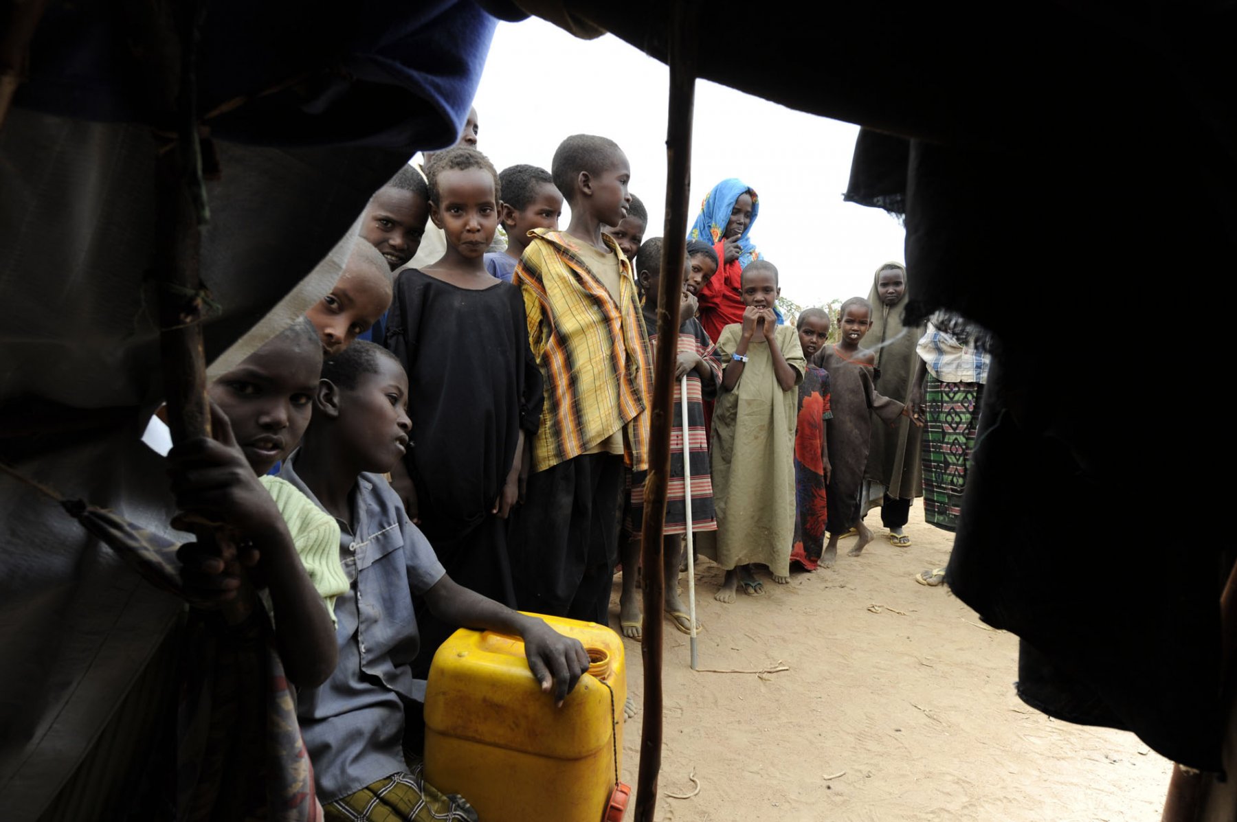 Young somalian refugees gather around a tent in a refugee camp in Dadaab, northeastern Kenya on Tuesday, August 2nd 2011. Somalia and parts of Kenya have been struck by one of the worst droughts and famines in six decades, more than 350.000 refugees have found shelter in the worlds biggest refugee camp. Foto: Boris Roessler dpa  +++(c) dpa - Bildfunk+++